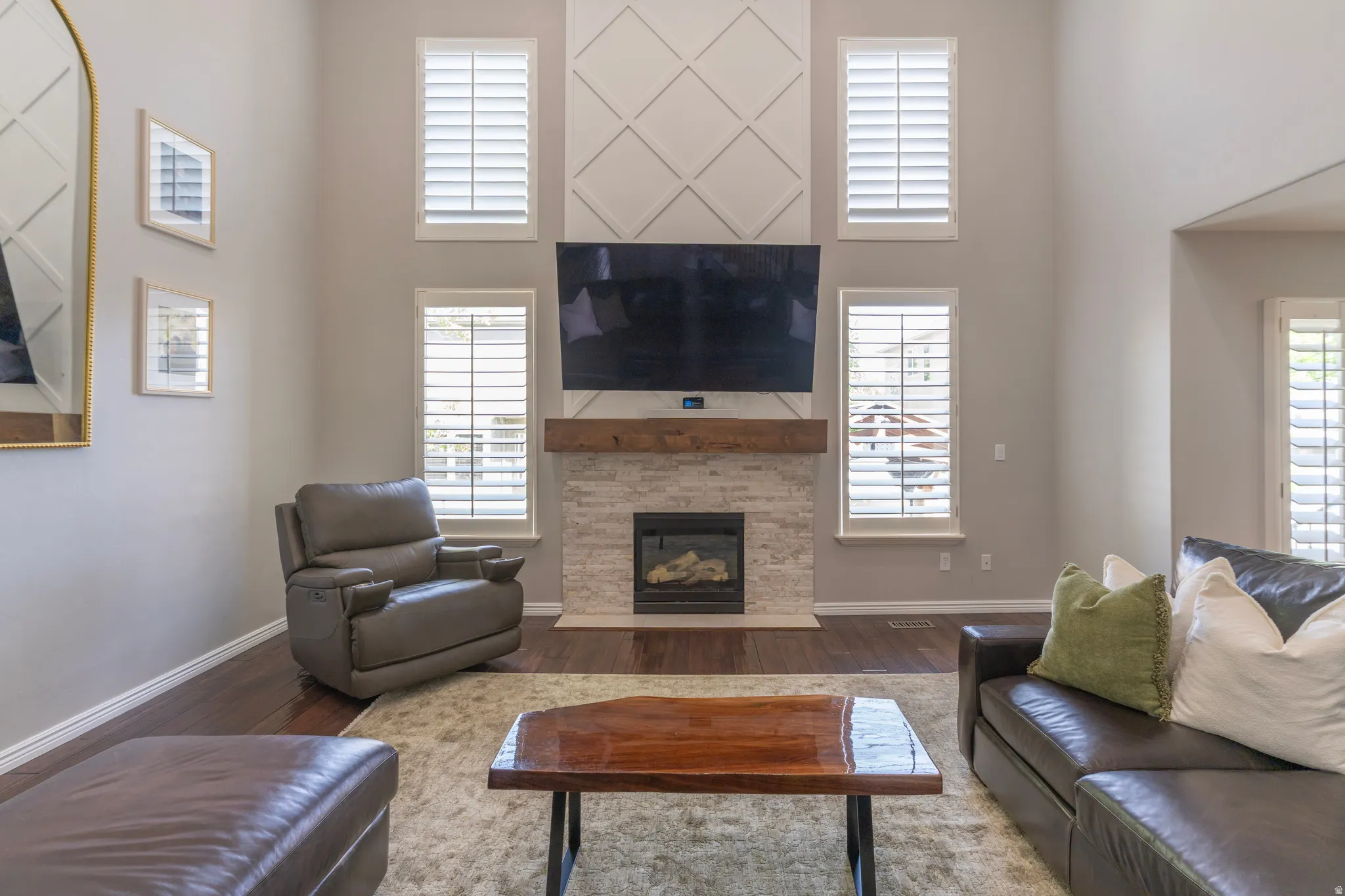 Living room with a high ceiling, a fireplace, and dark wood-style flooring