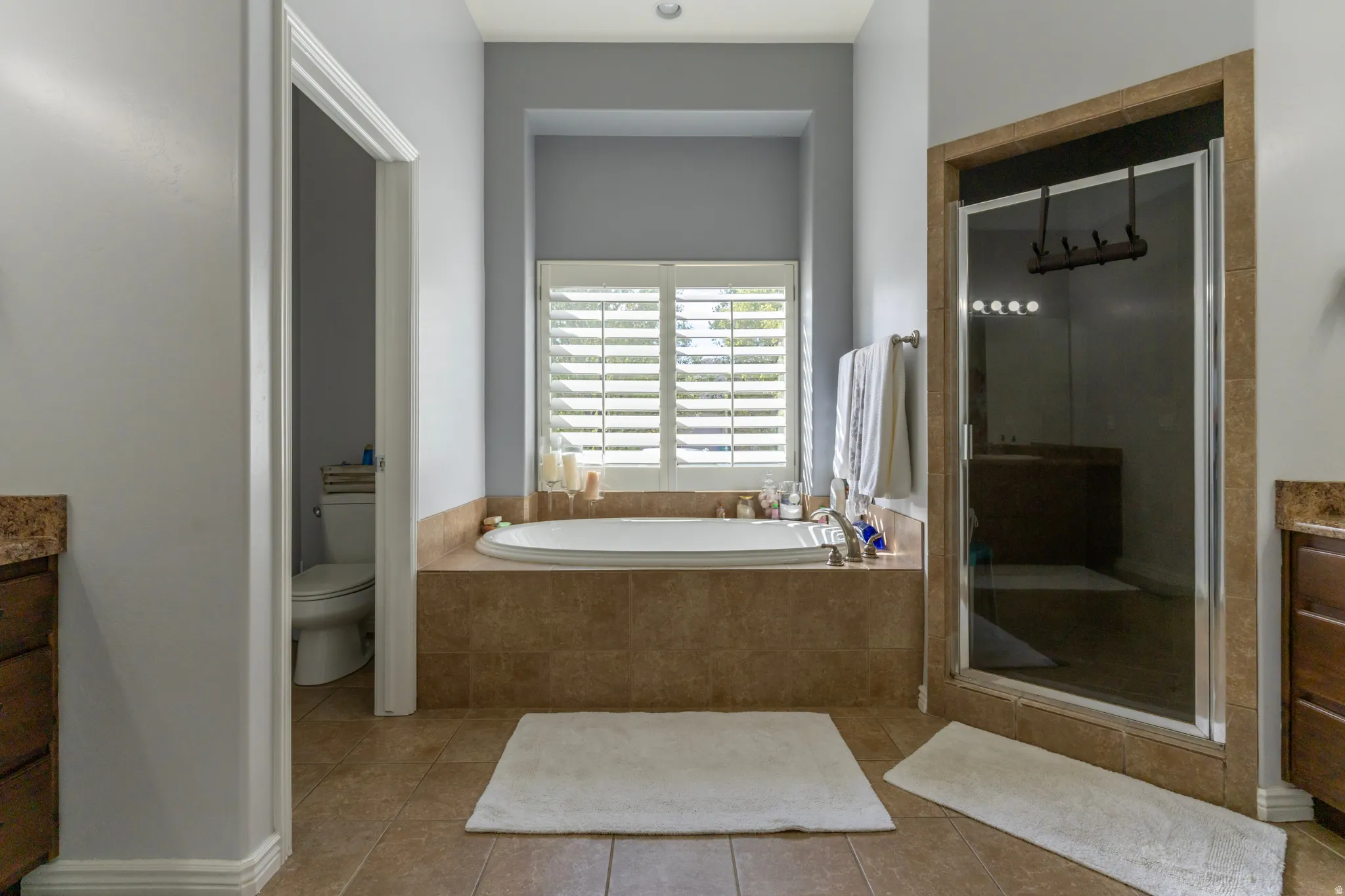 Bathroom with vanity, a stall shower, a bath, and light tile patterned floors