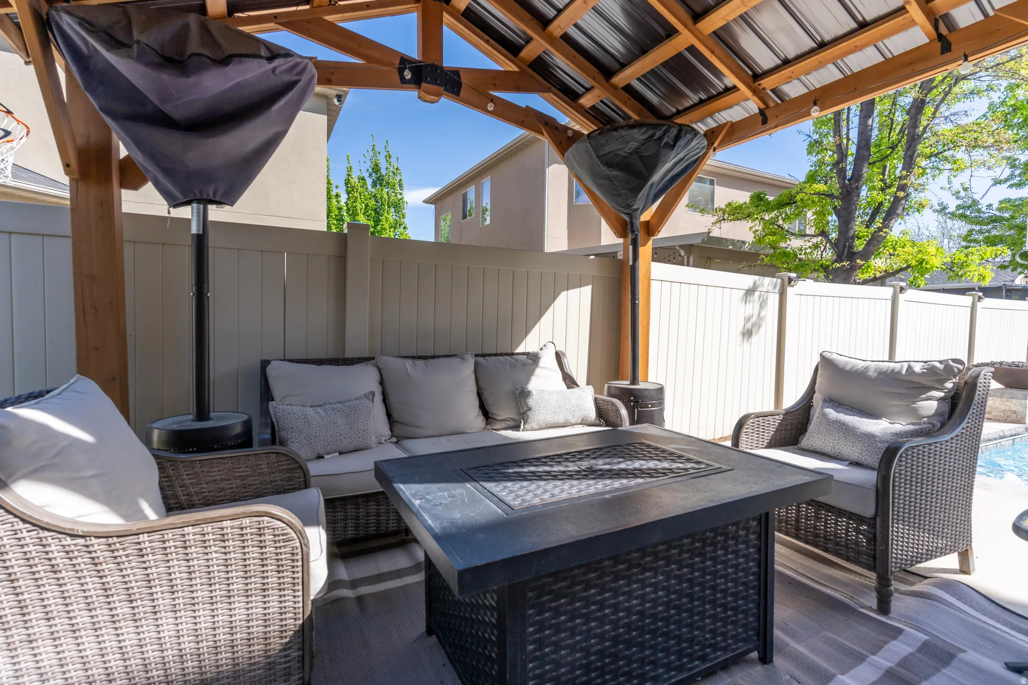 Fenced backyard featuring an outdoor living space with a fire pit and a patio
