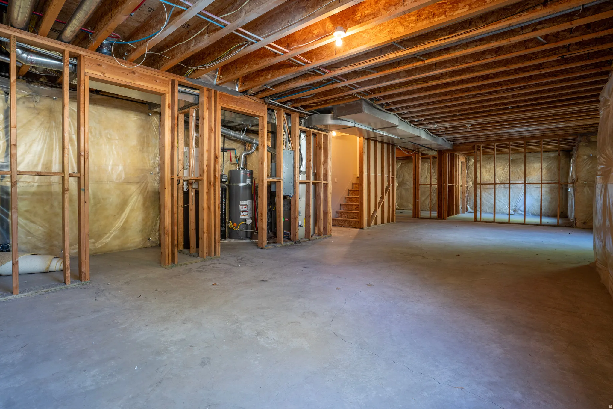 Unfinished below grade area with water heater and stairway