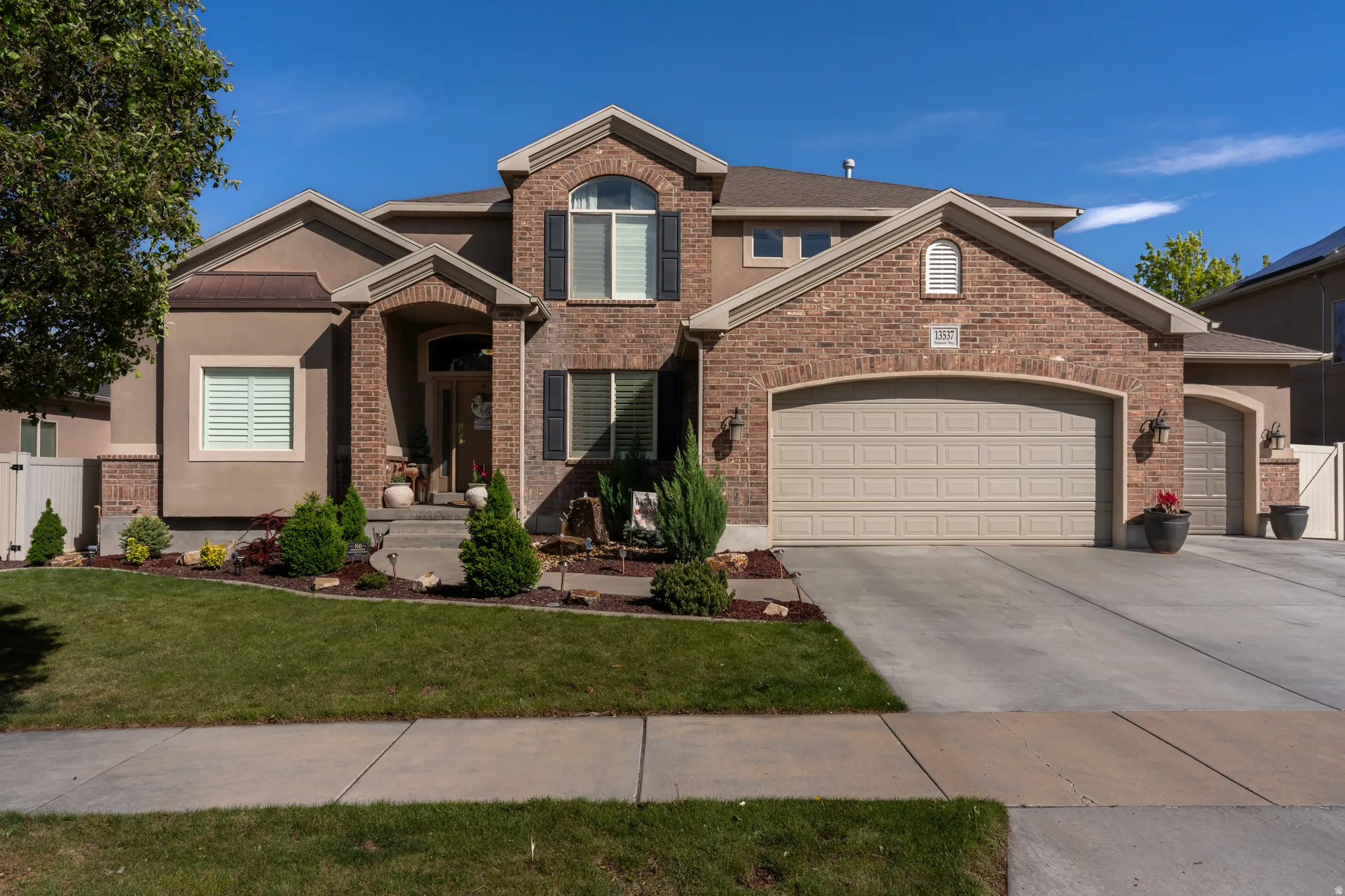 View of front of home featuring a garage, concrete driveway, and brick siding