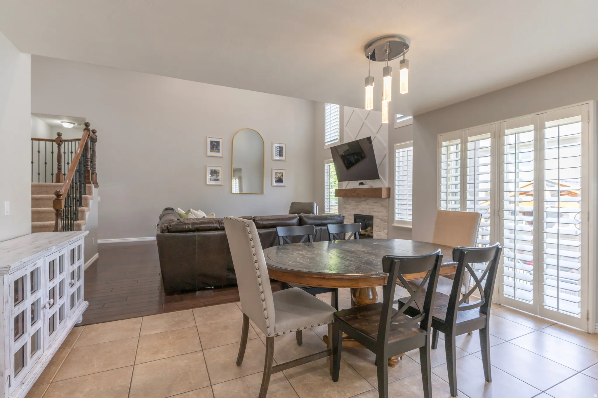 Dining space featuring light tile patterned floors and a fireplace