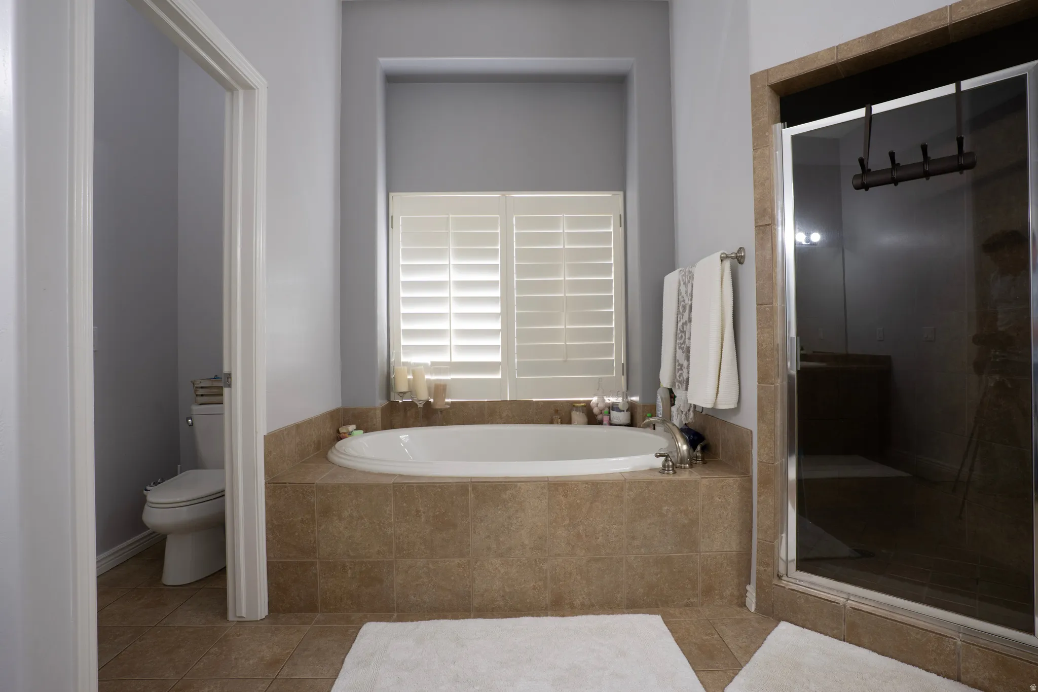 Full bath featuring a stall shower, a bath, and tile patterned floors
