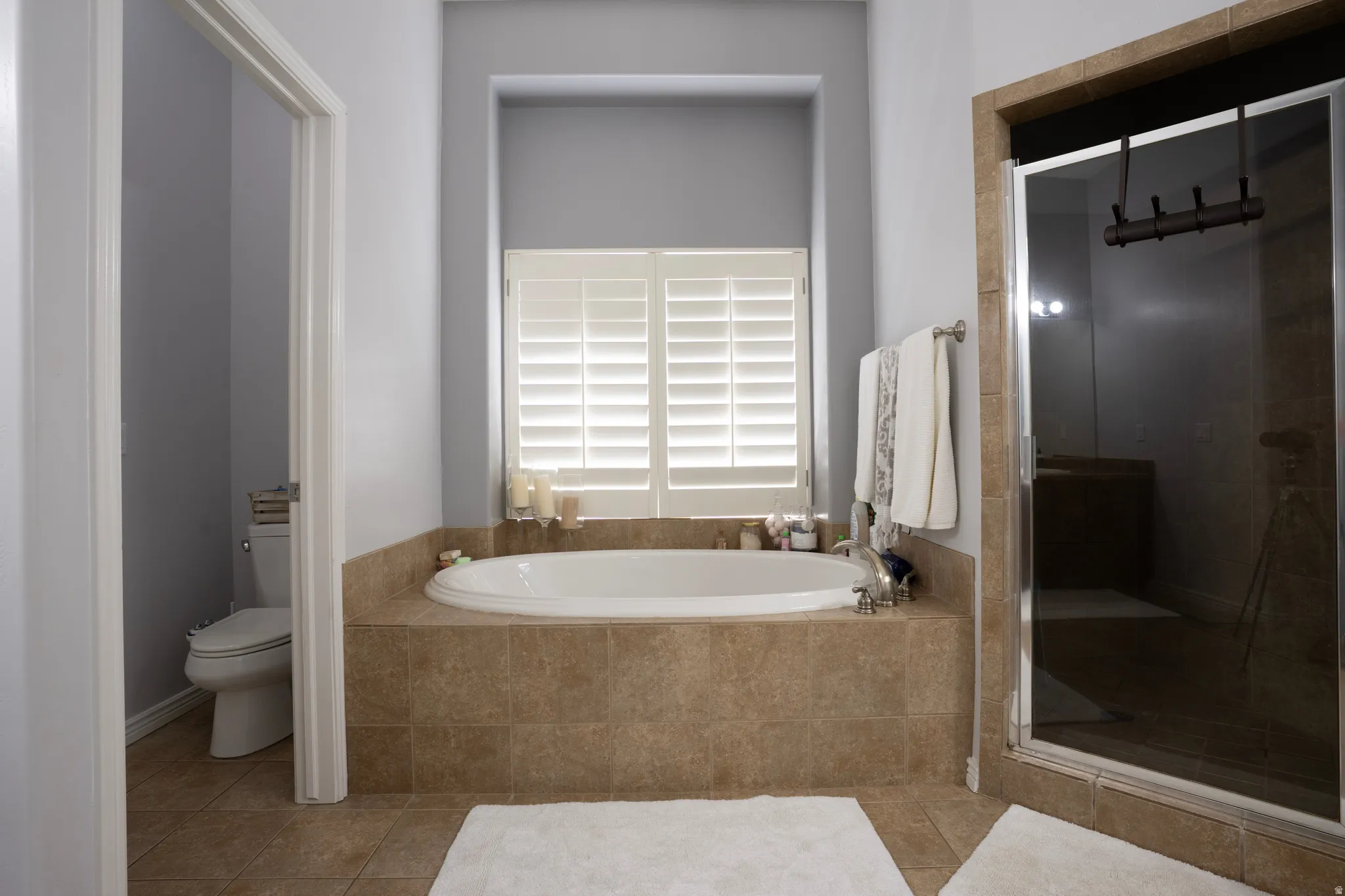 Full bathroom featuring a stall shower, a garden tub, and tile patterned floors