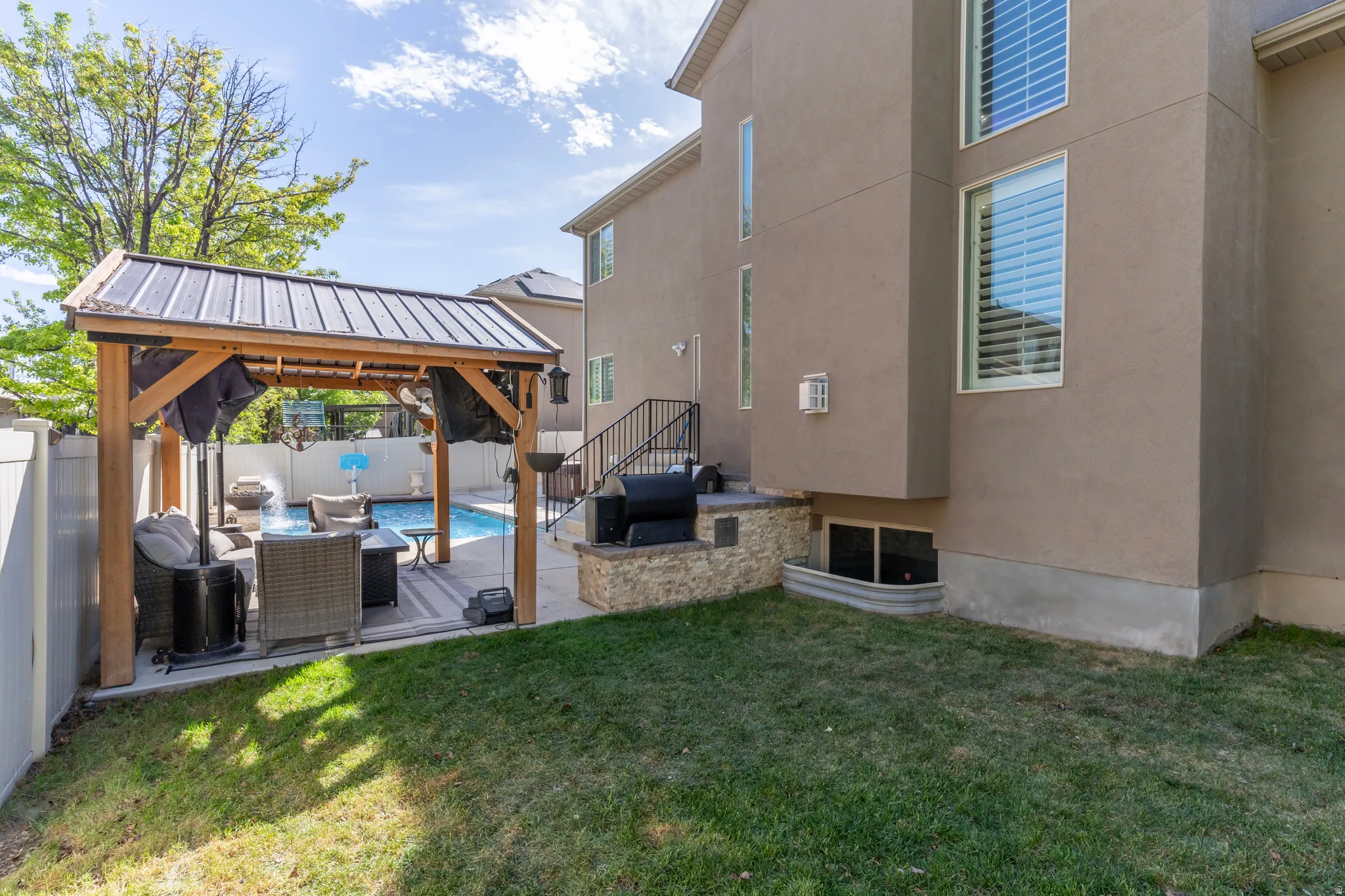 Fenced backyard featuring a gazebo, a patio area, and an outdoor lounge area