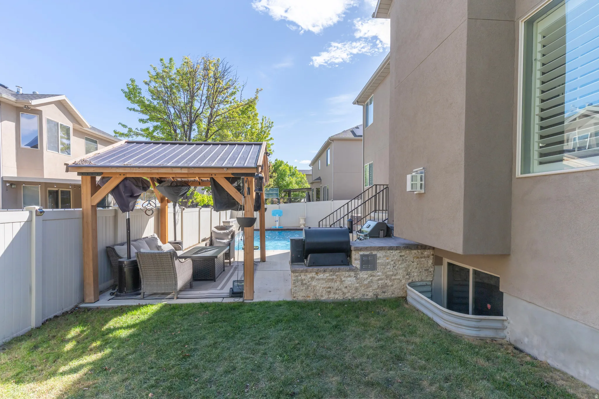 Fenced backyard featuring an outdoor lounge area, a patio area, a gazebo, and oil tank