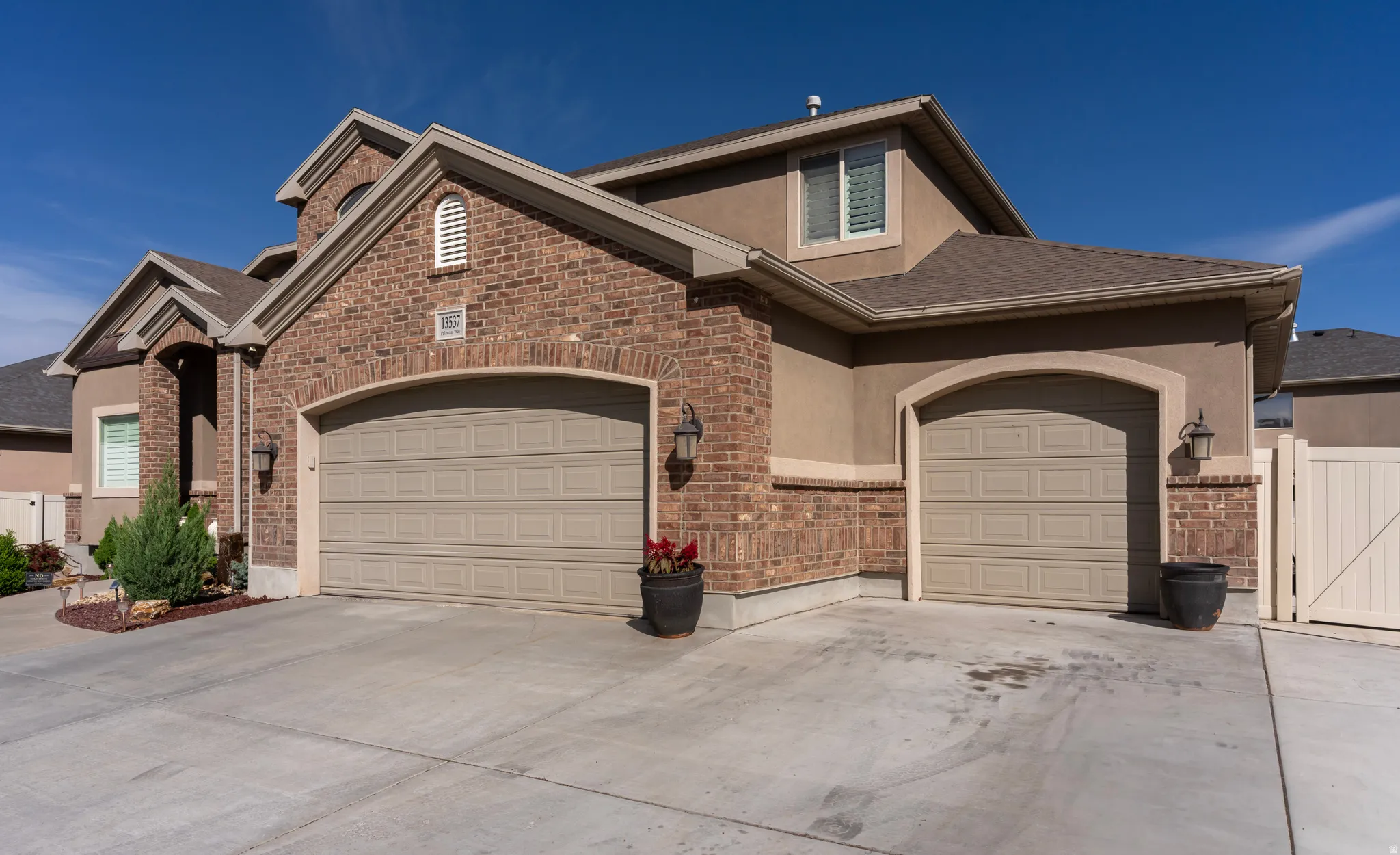 View of front of house featuring a gate, stucco siding, driveway, and a garage