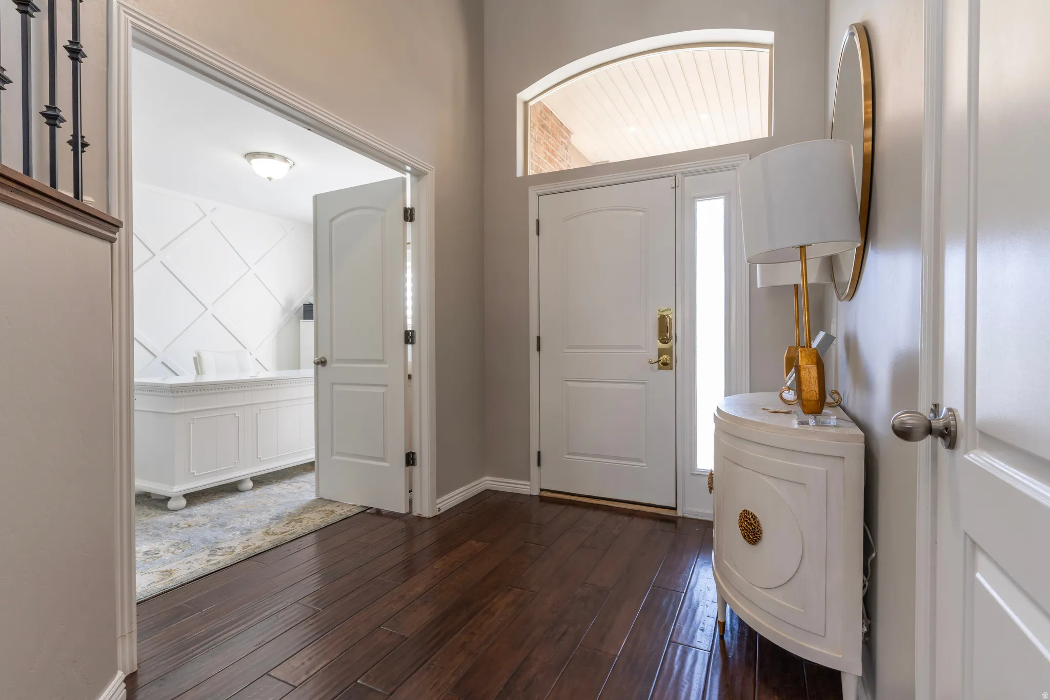 Foyer entrance featuring dark wood-style flooring and baseboards
