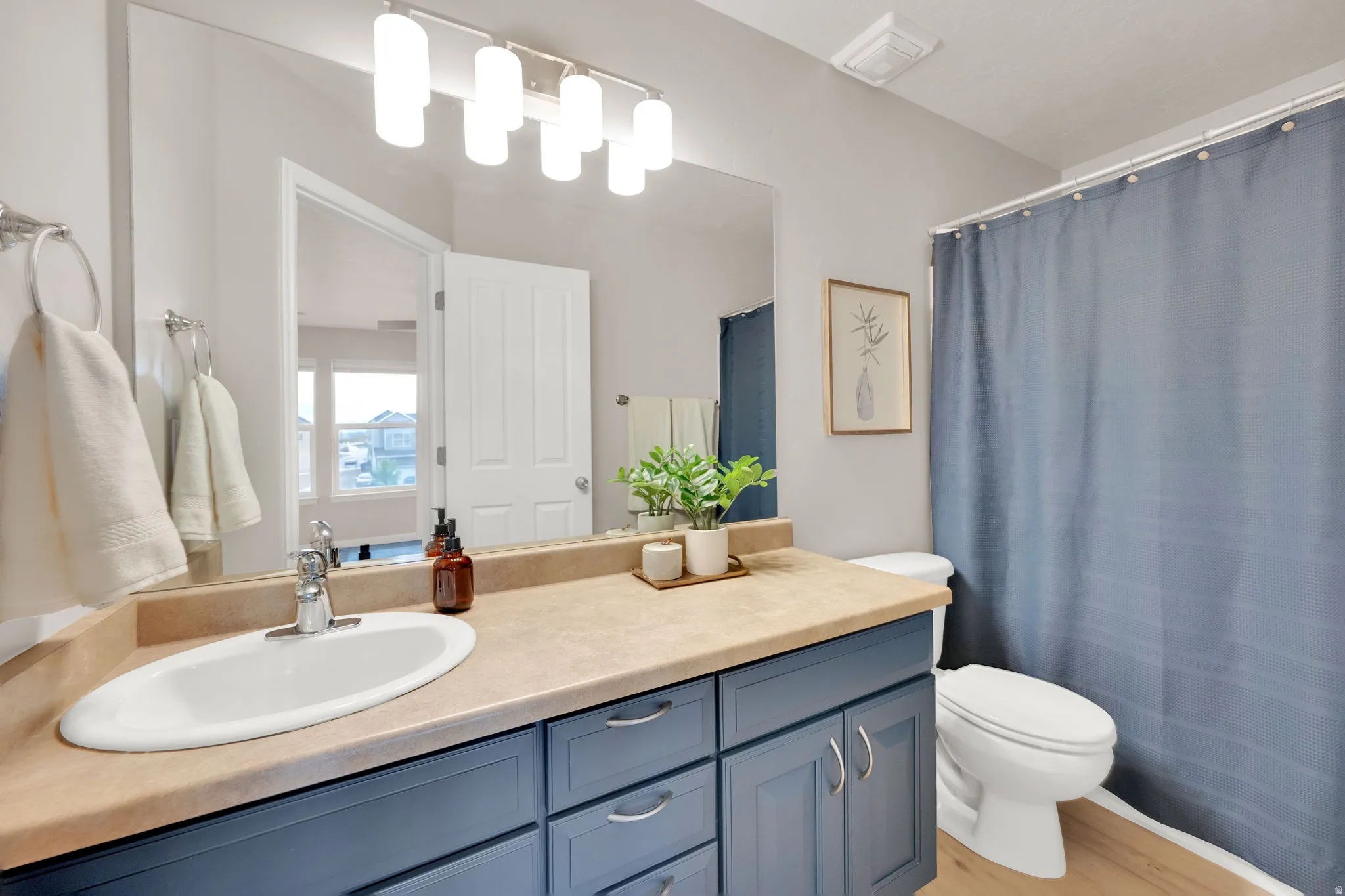 Primary Bathroom, full bath with vanity, a shower with shower curtain, and light wood-style floors