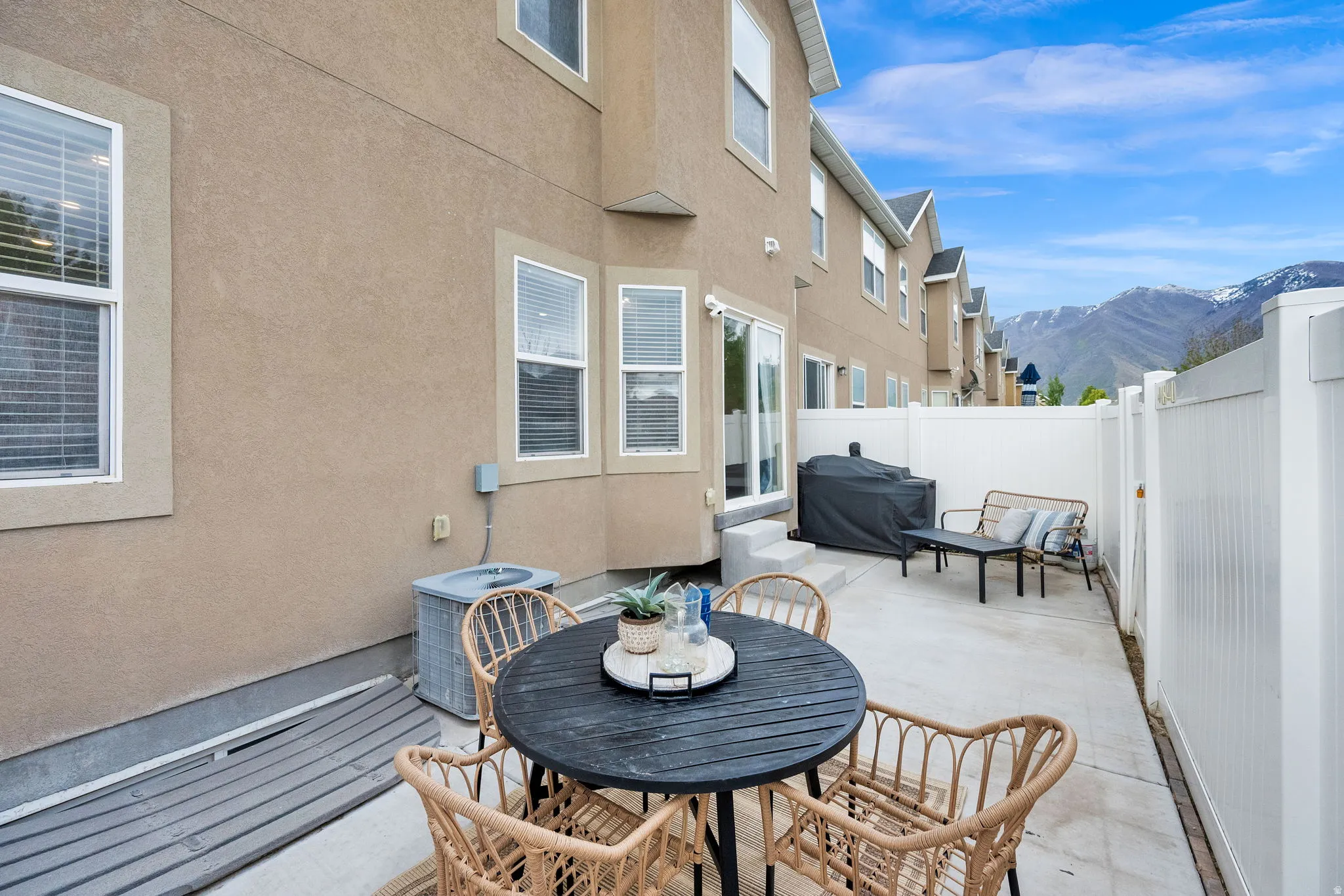 Fenced backyard with a mountain view, grilling area, outdoor dining space, and a patio area
