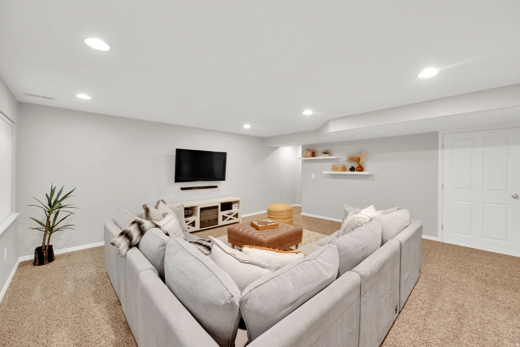 Living area featuring light colored carpet and recessed lighting