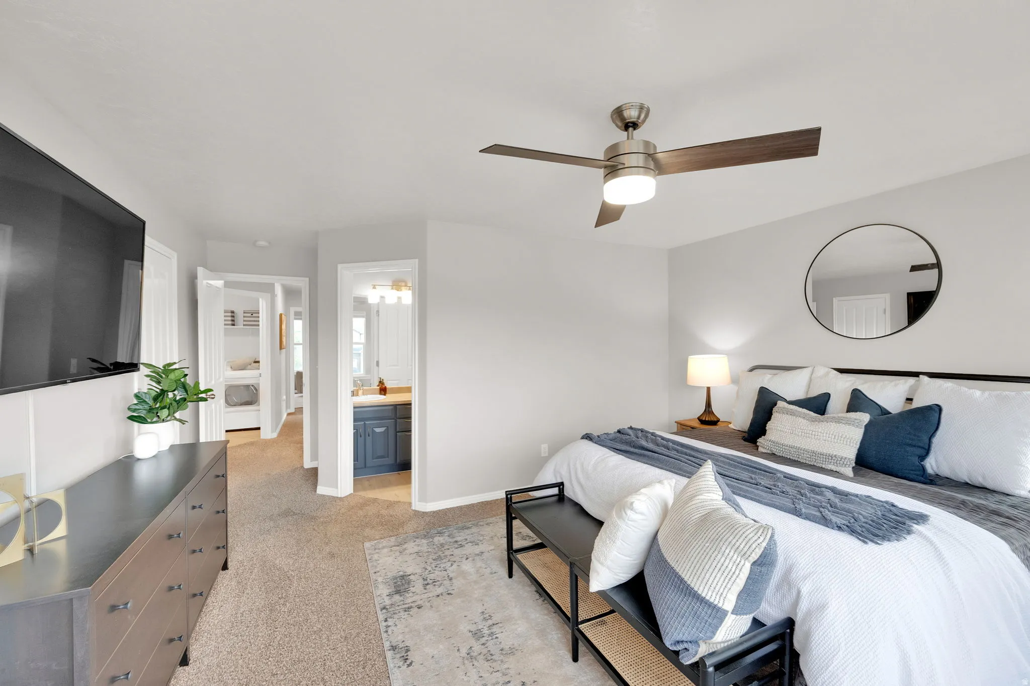 Primary Bedroom with light colored carpet, ceiling fan, and connected bathroom