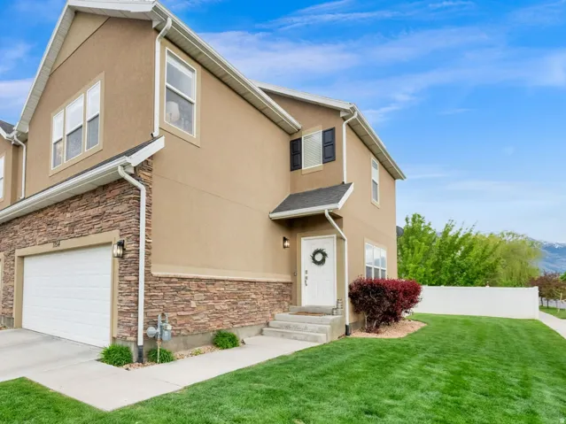 View of front of home featuring stone siding, stucco siding, concrete driveway, a mountain view, and an attached garage