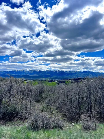 Expansive mountain range backdrop with distant residential structures