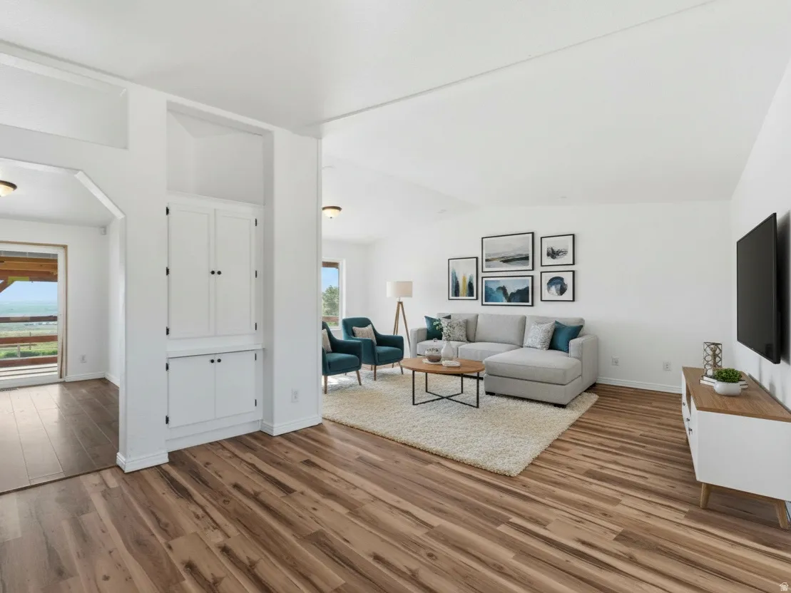 Living room with lofted ceiling and light wood-style floors