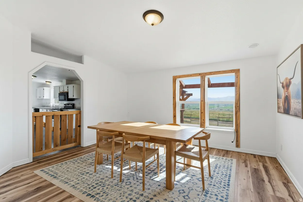 Dining room featuring arched walkways and light wood-style floors