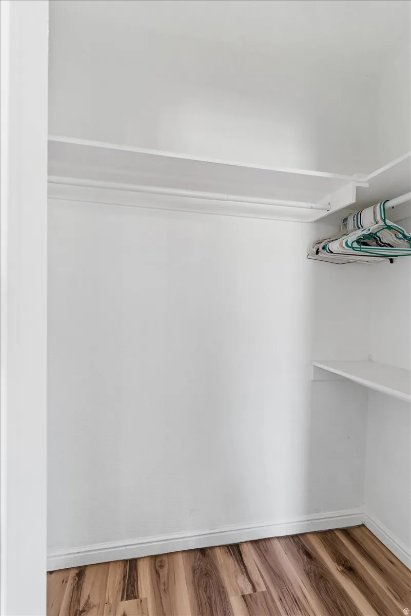Walk in closet with light wood finished floors