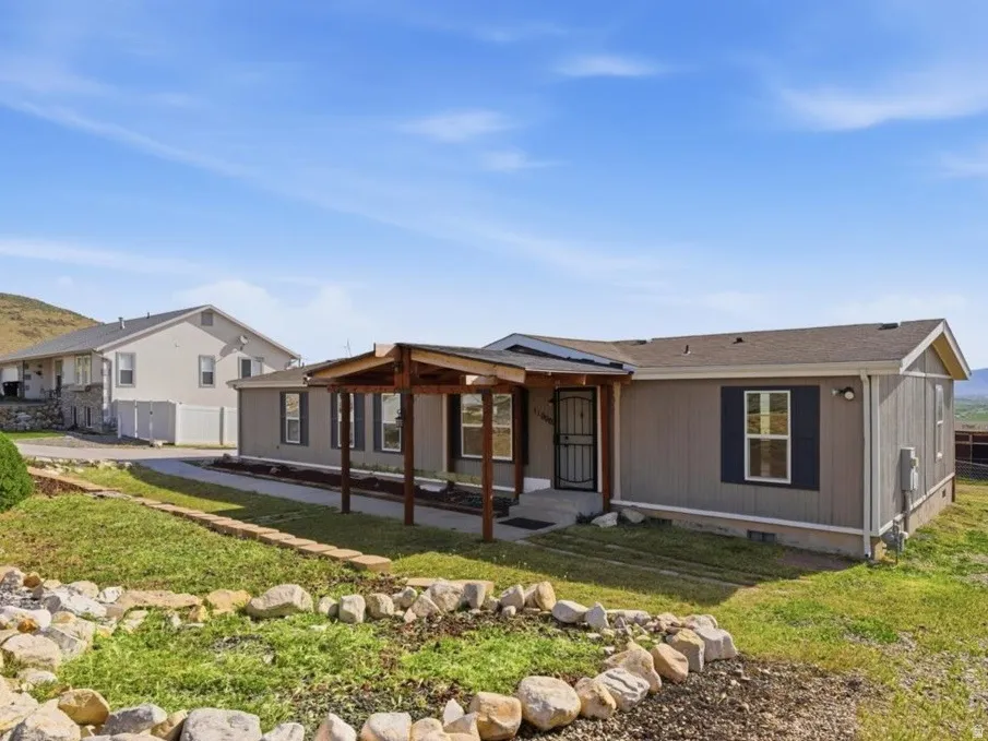 Rear view of property with a mountain view, crawl space, and a patio