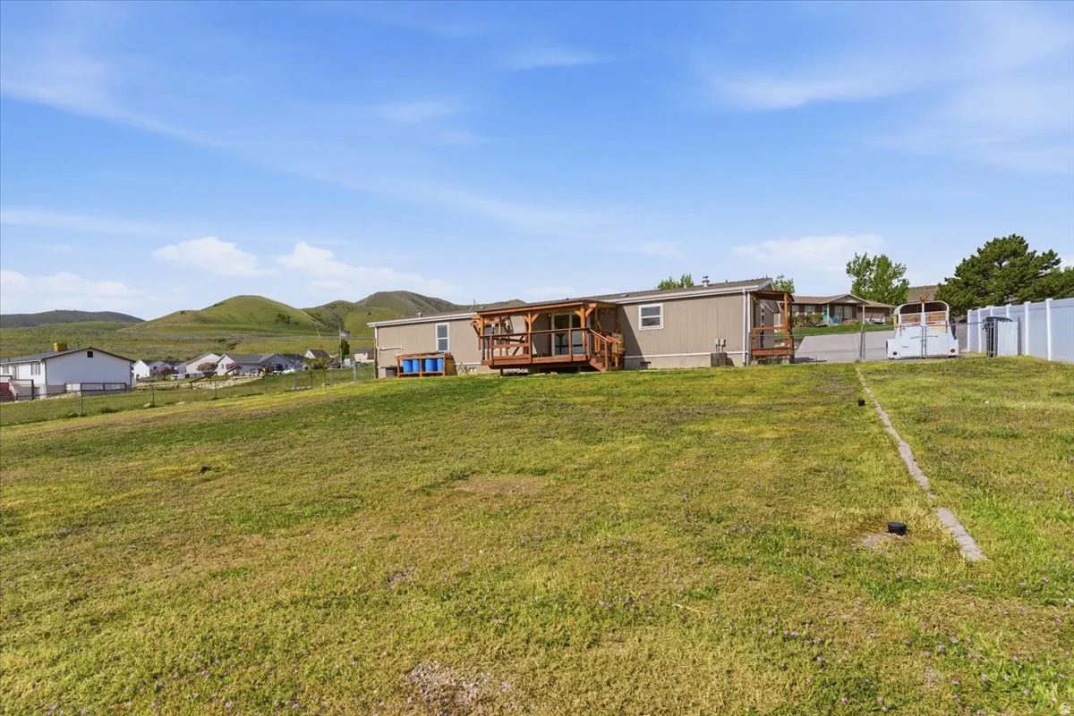 Back of house featuring a fenced backyard and a deck with mountain view