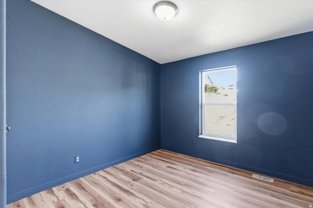 Unfurnished room featuring light wood-style floors and baseboards