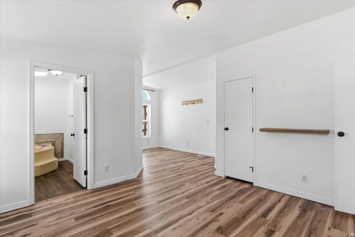 Unfurnished bedroom with light wood-style flooring and ensuite bathroom