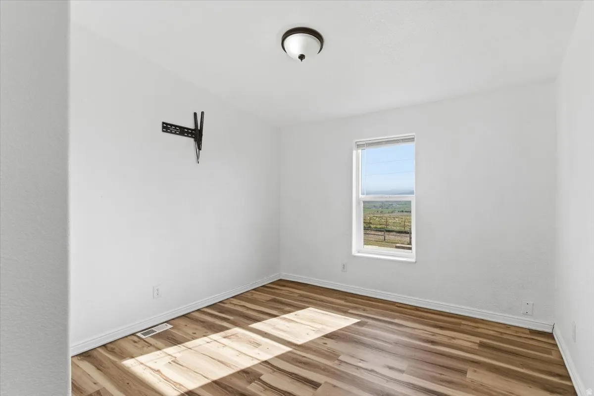 Empty room featuring baseboards and light wood-style flooring