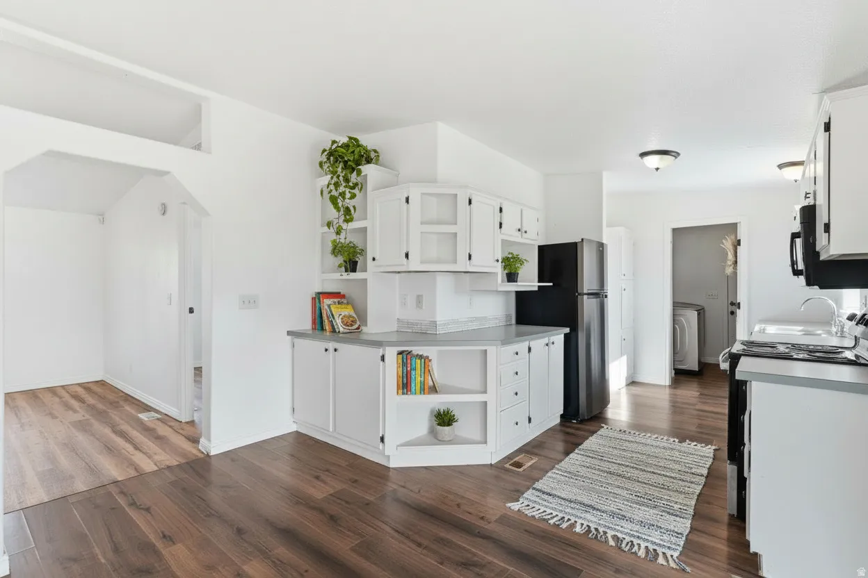 Kitchen featuring open shelves, white cabinetry, freestanding range oven, and dark wood finished floors