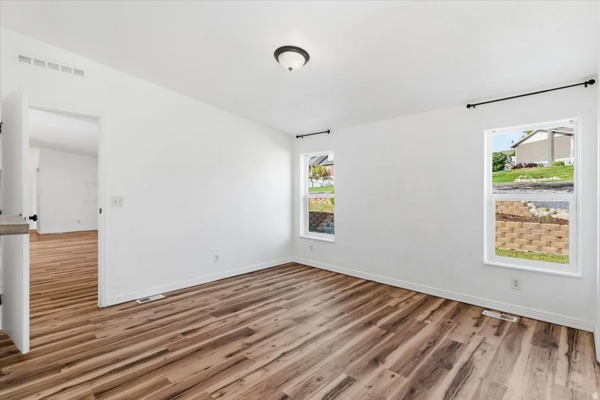 Spare room featuring light wood-style flooring and baseboards