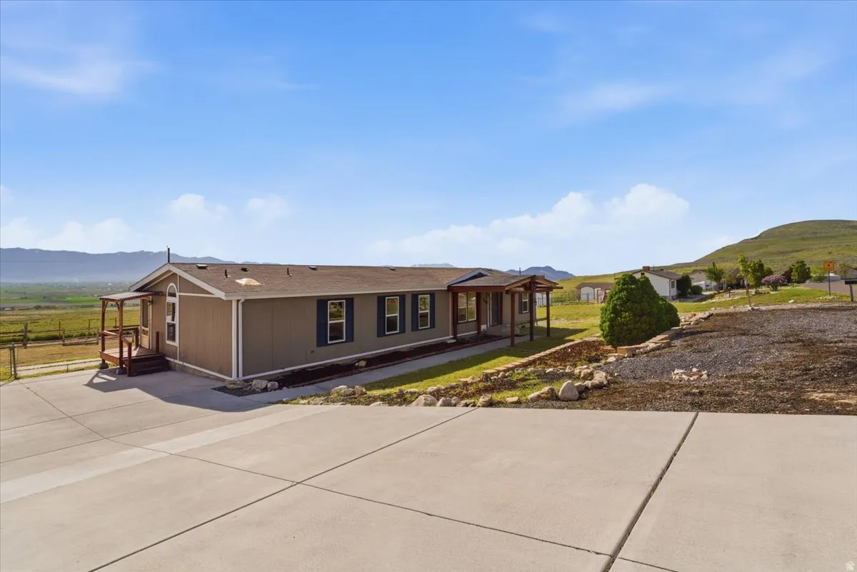 View of front of home featuring a mountain view, driveway, and a shingled roof