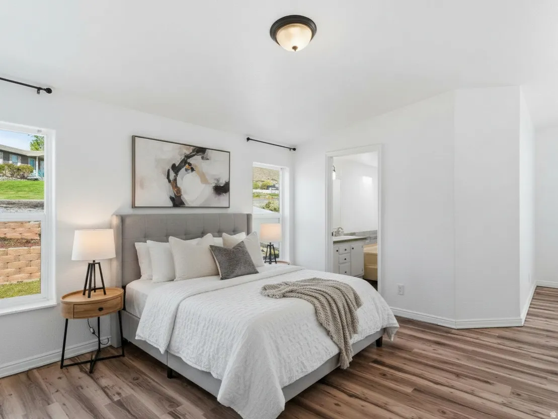 Bedroom with wood finished floors and connected bathroom