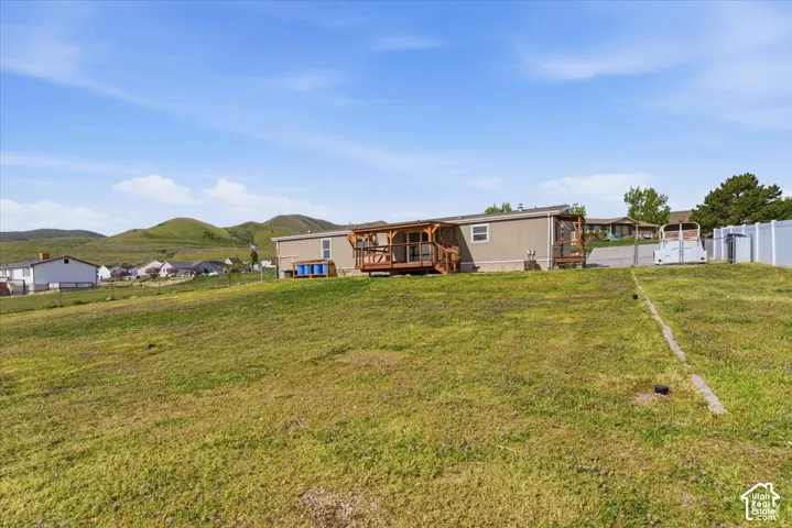 Back of house featuring a fenced backyard and a deck with mountain view