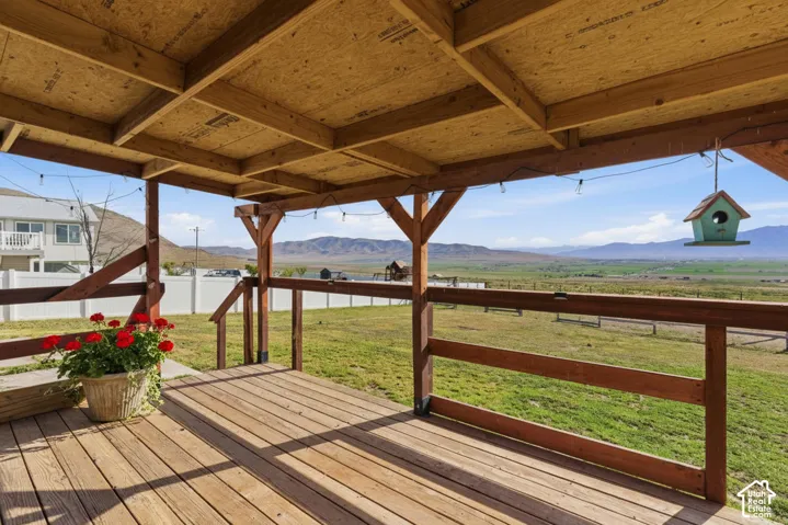 Wooden terrace with a mountain view and a fenced backyard