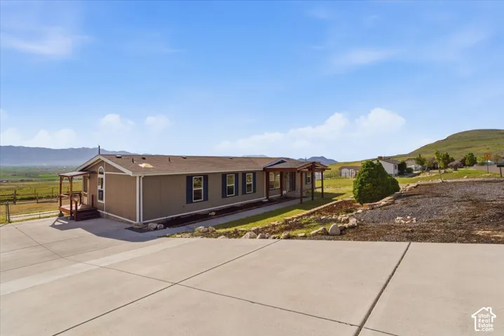View of front of home featuring a mountain view, driveway, and a shingled roof