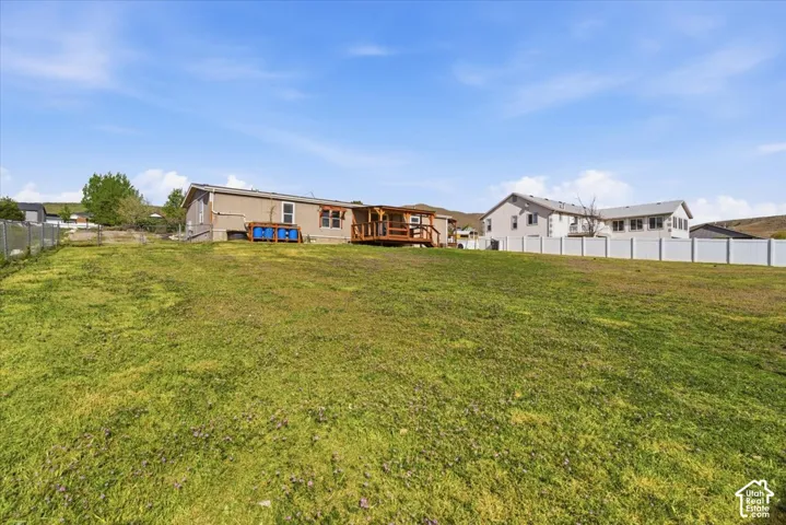 Back of property featuring a fenced backyard and a wooden deck