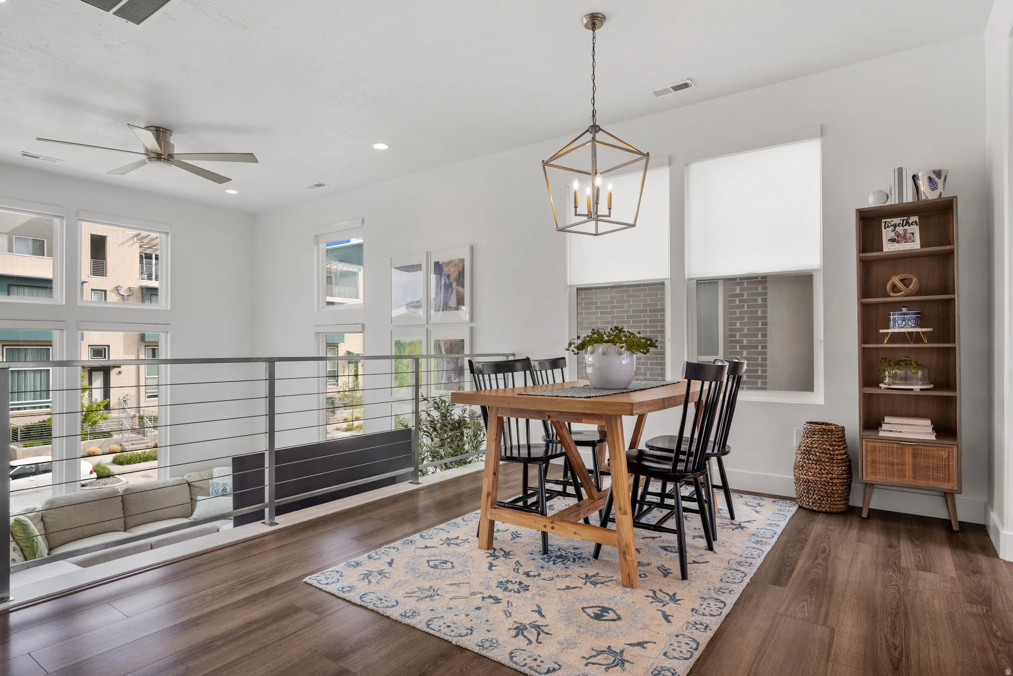 Dining room featuring dark wood-style floors, a ceiling fan, and a chandelier