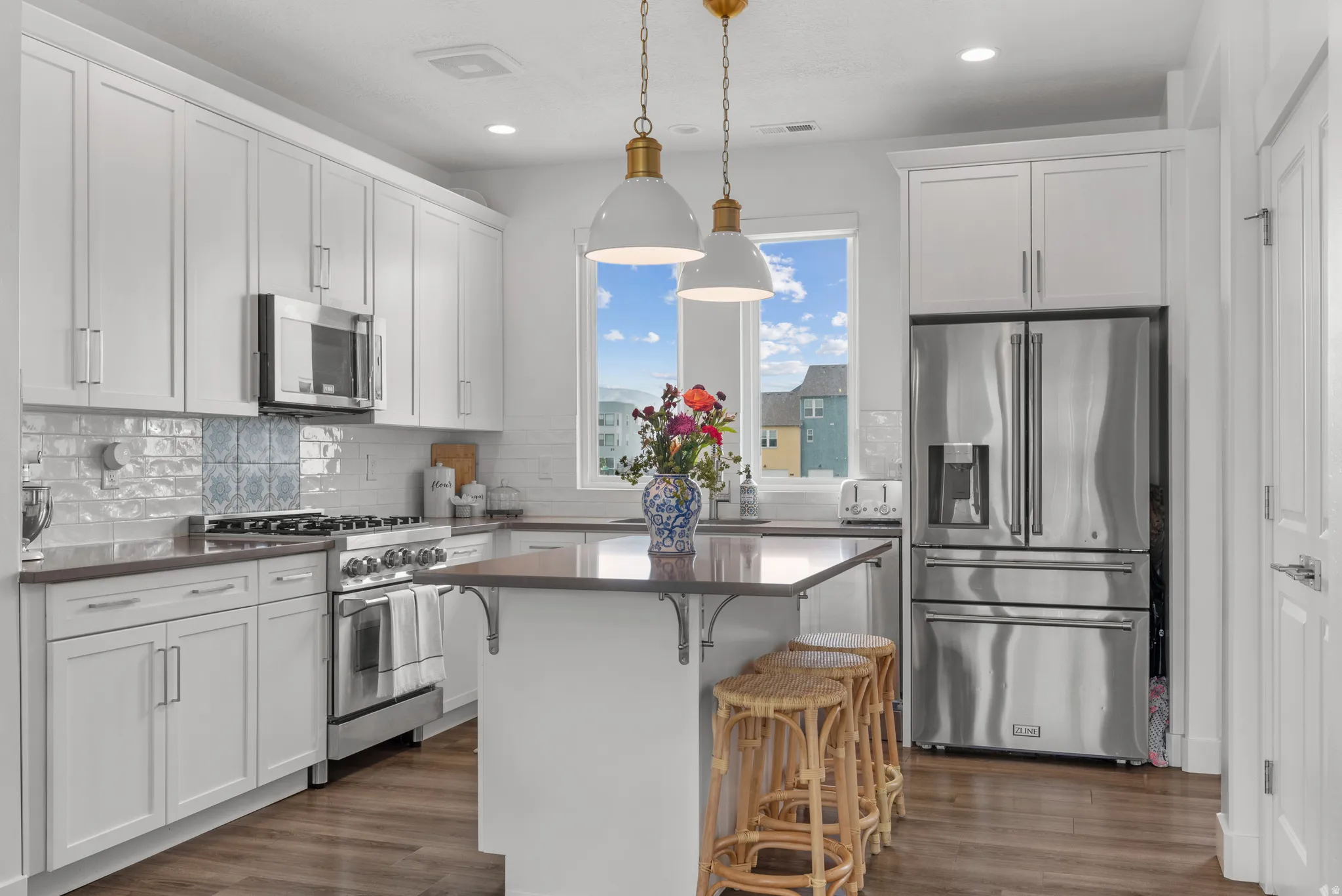 Kitchen with premium appliances, a breakfast bar area, a kitchen island, and white cabinets