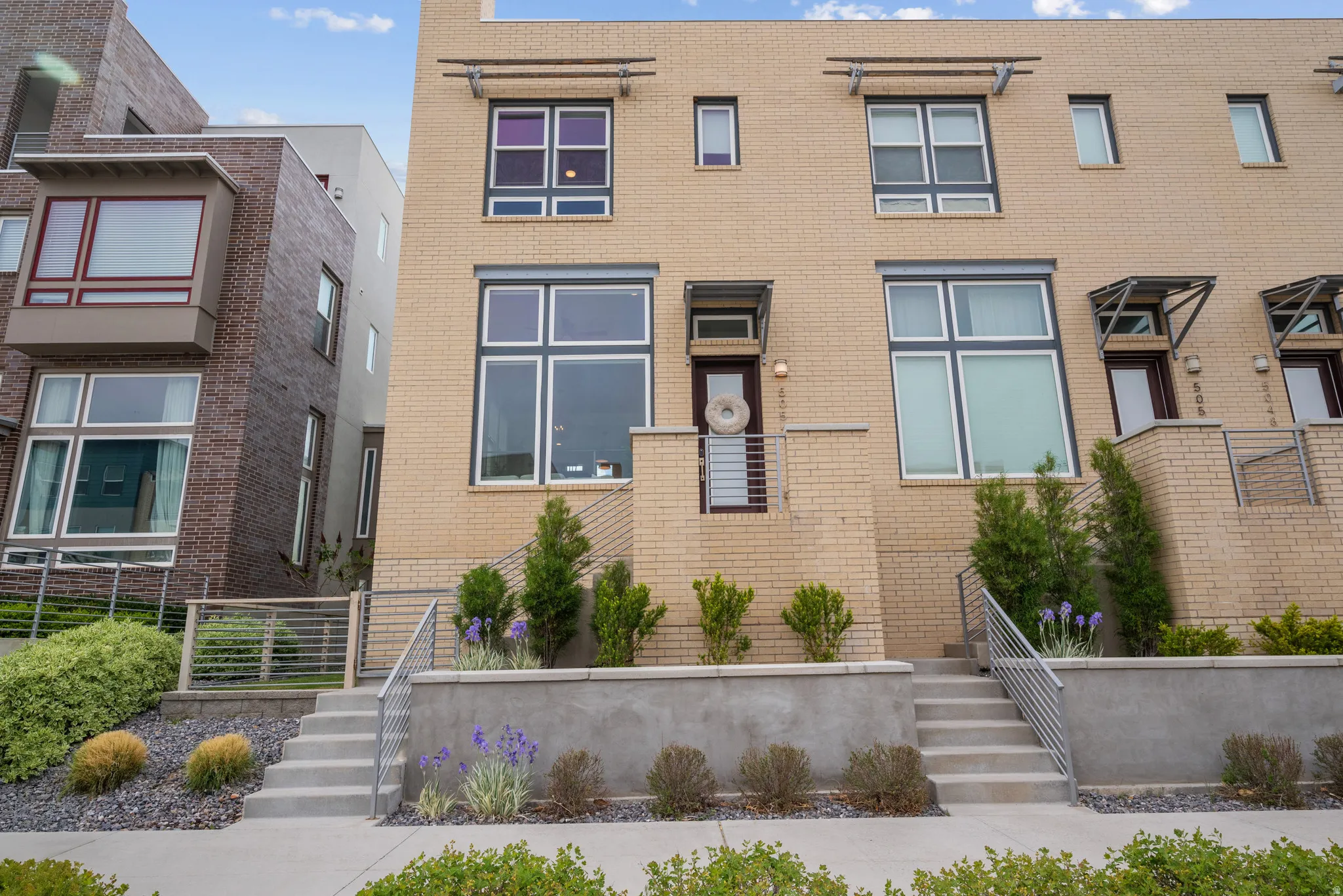 View of front facade featuring stairway and brick siding