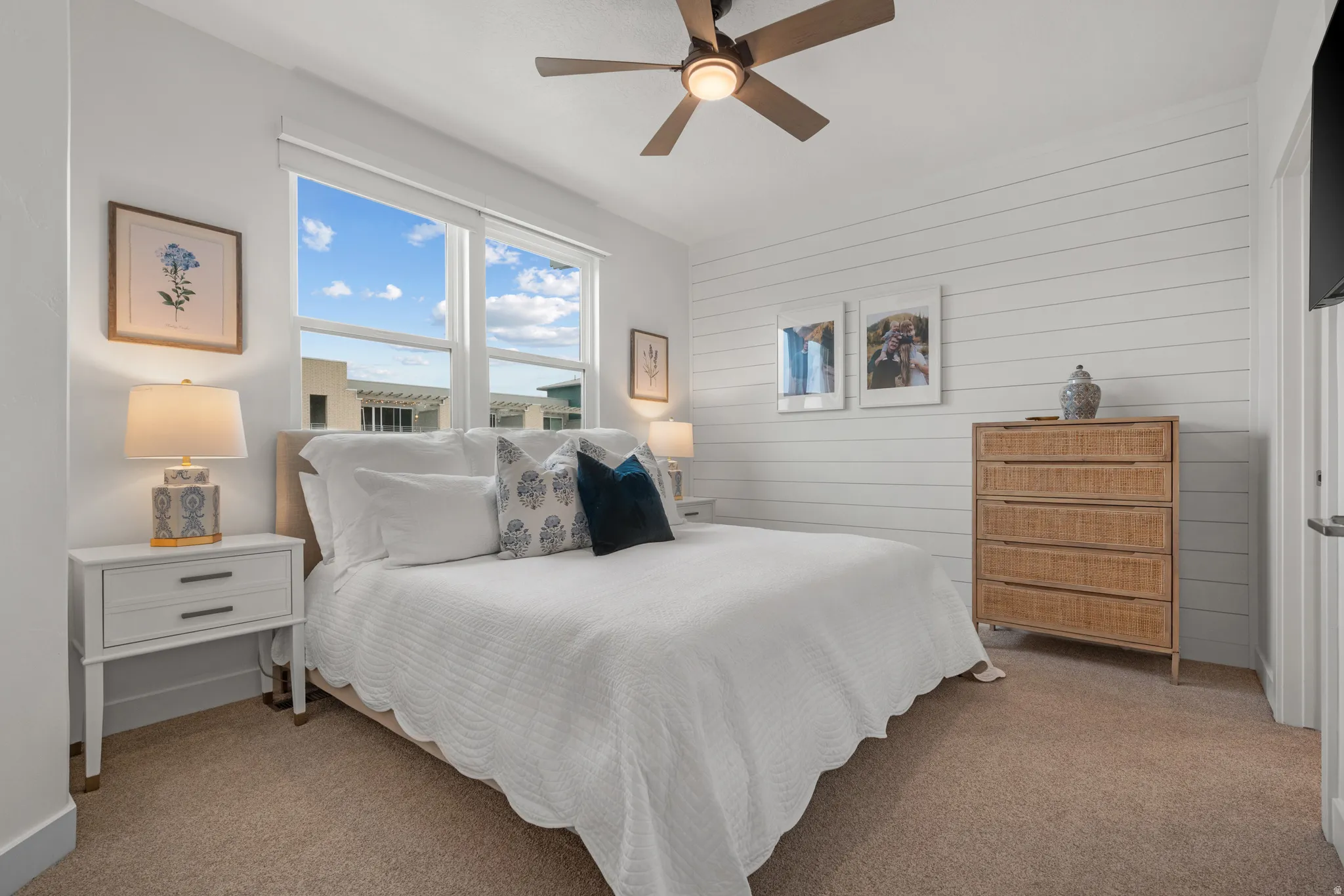 Bedroom featuring carpet floors, a ceiling fan, and wood walls
