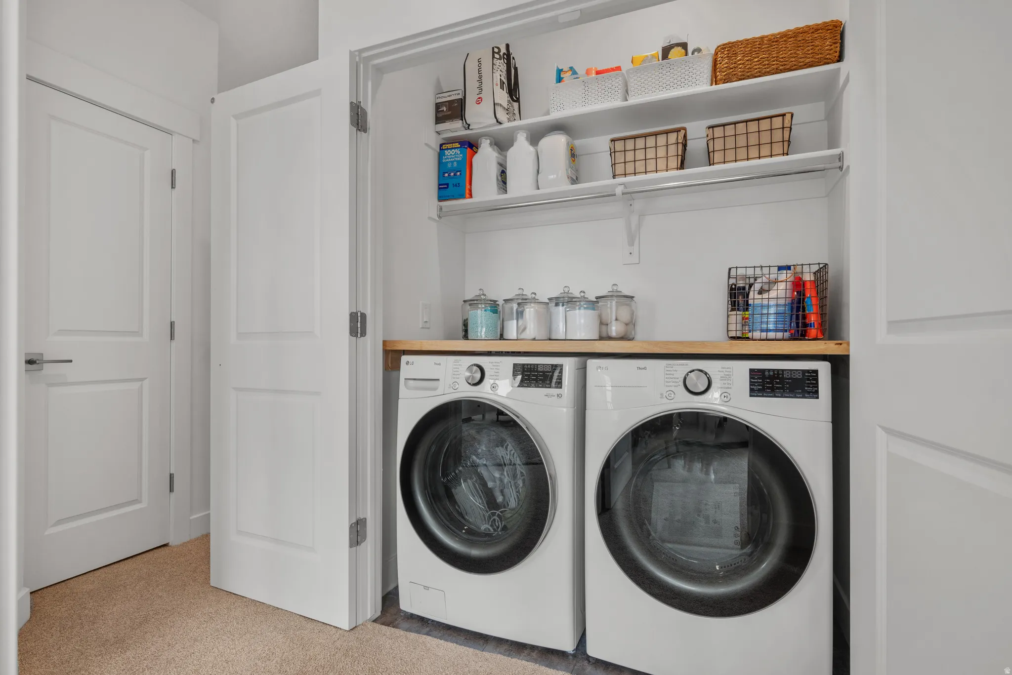 Laundry area featuring washer and dryer and light colored carpet