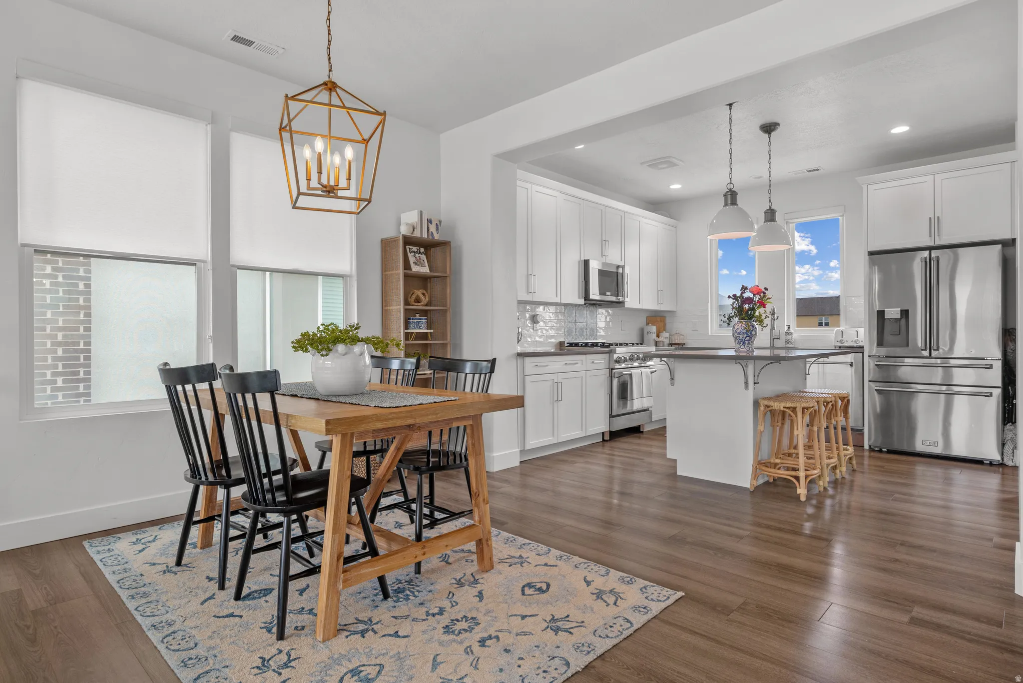Dining room with dark wood finished floors and suspended lighting