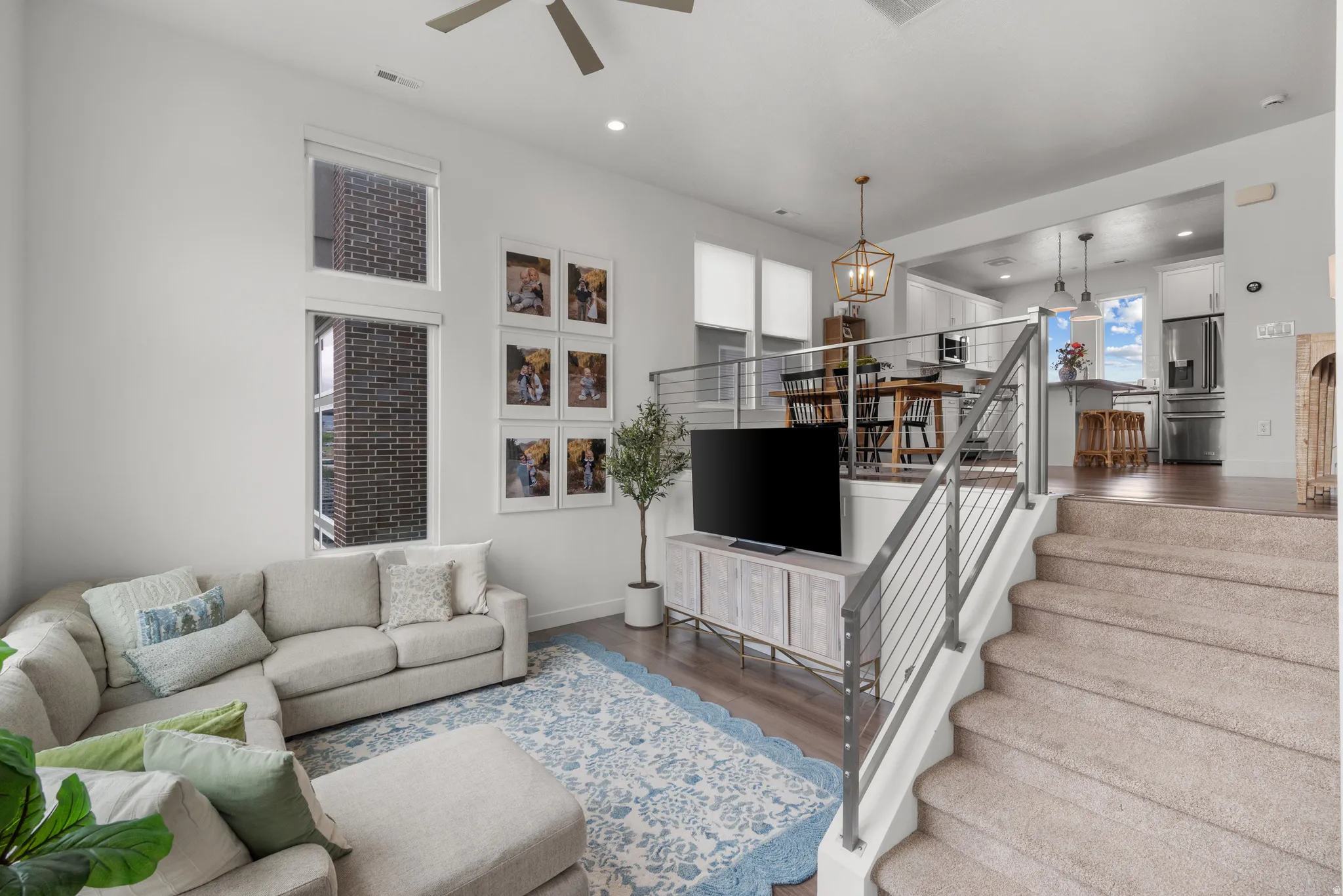 Living area with wood finished floors, ceiling fan, and recessed lighting