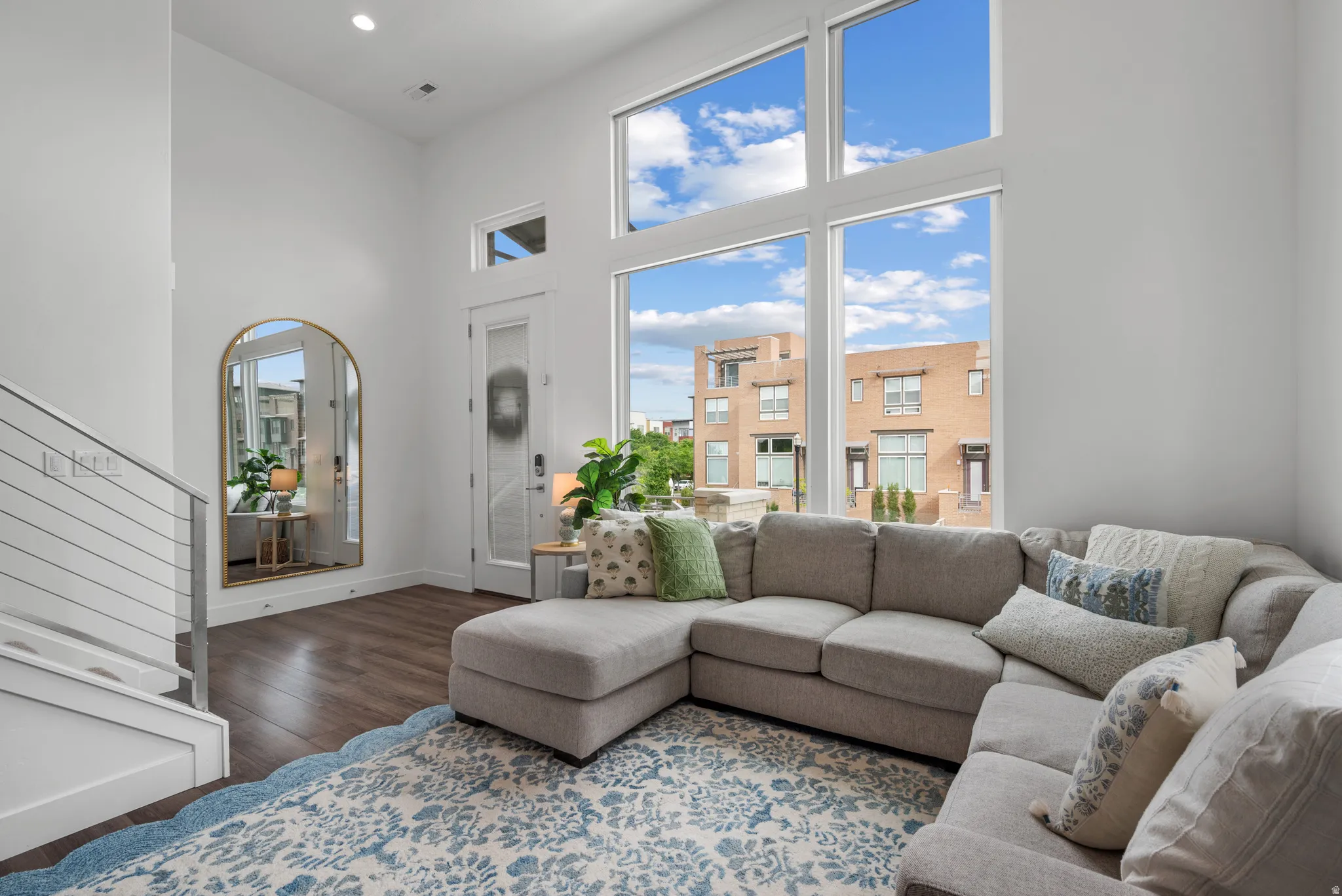 Living area featuring dark wood-style flooring, a high ceiling, and recessed lighting