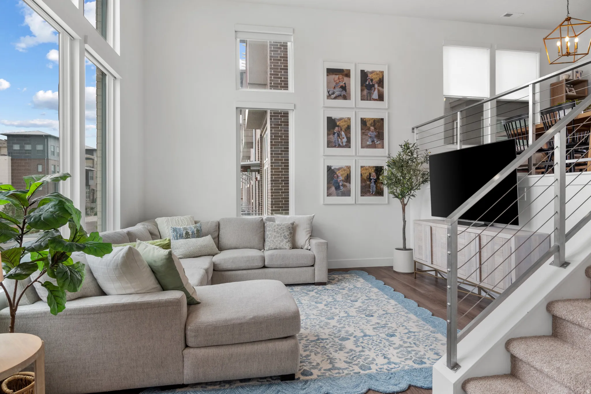 Living area with wood finished floors and suspended lighting