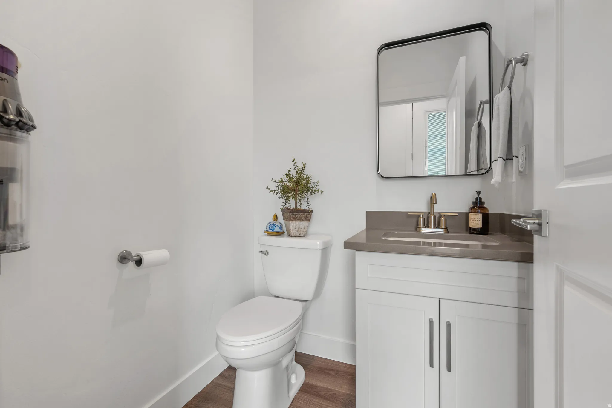 Half bath with vanity and dark wood-style floors