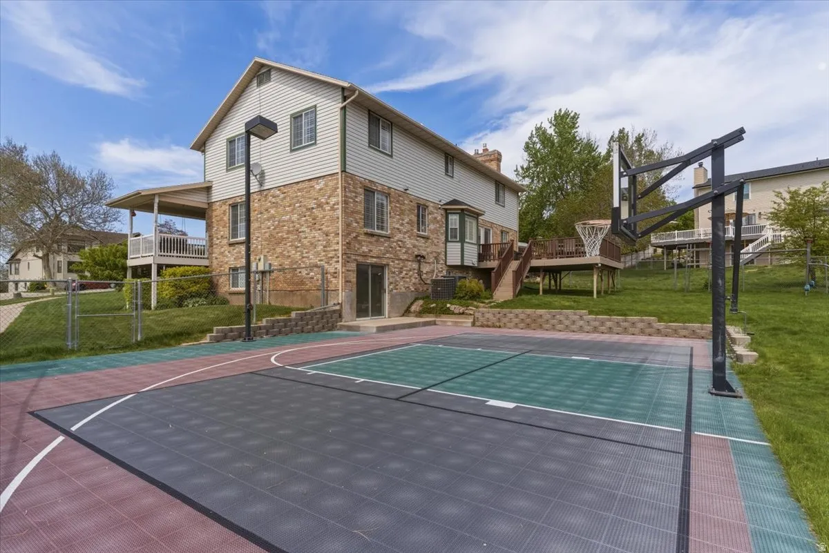View of basketball court featuring basketball hoop and a deck