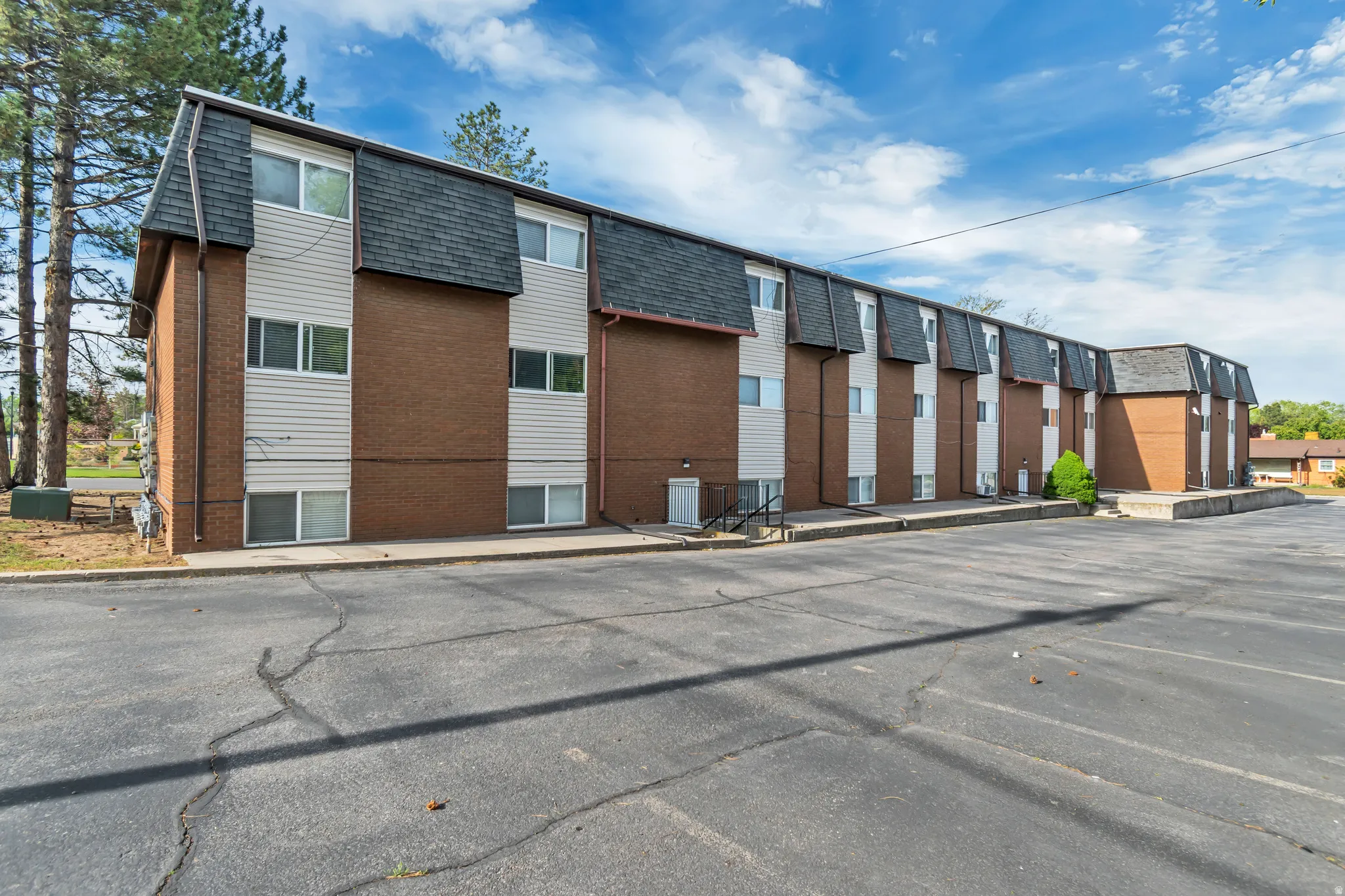 View of apartment building / complex with uncovered parking