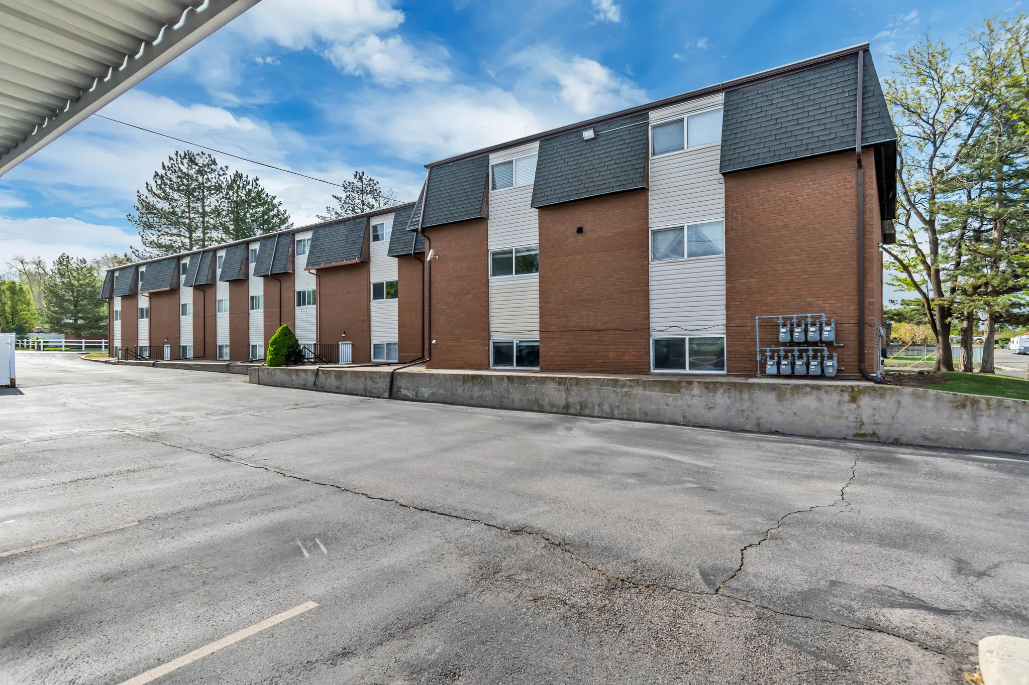 View of apartment building / complex featuring uncovered parking