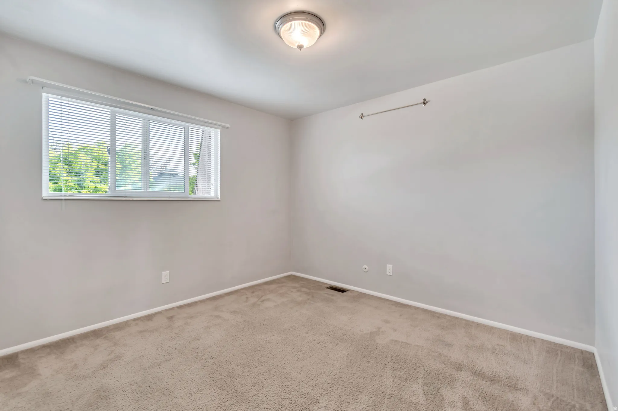 Carpeted empty room featuring baseboards