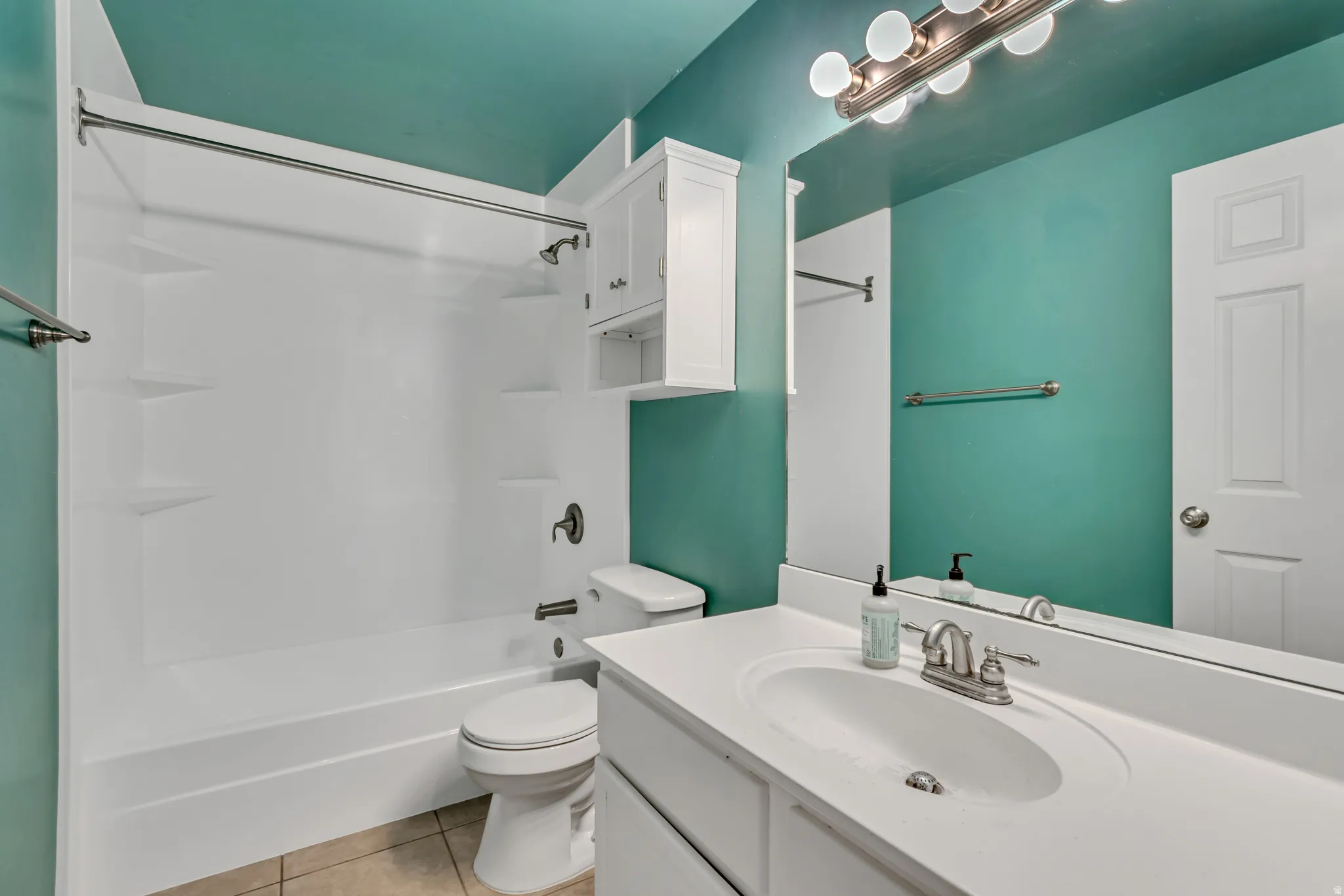 Full bath featuring vanity, shower / washtub combination, and light tile patterned floors