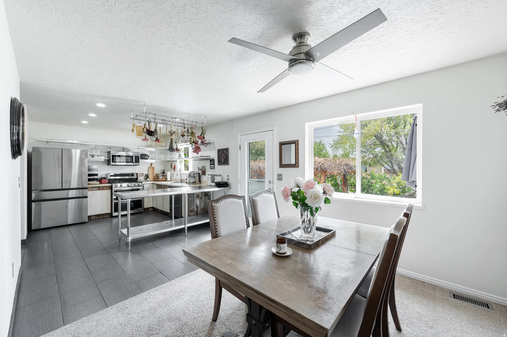 Dining space with a textured ceiling, recessed lighting, and a ceiling fan